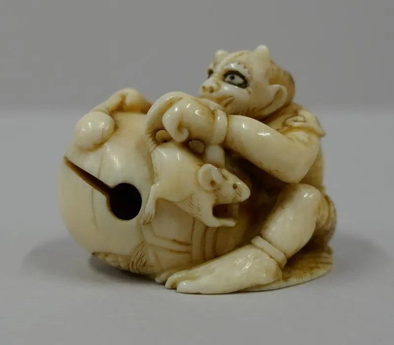 Netsuke: Oni to mokugyo [A Devil and a wooden gong]; Netsuke in the form of a demon with a wooden gong and a rat.