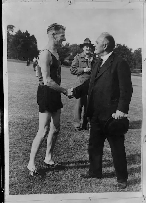 New Zealand High Commissioner William Joseph Jordan congratulates E J Johnson on winning the mile at NZ Forestry Company sports, World War II