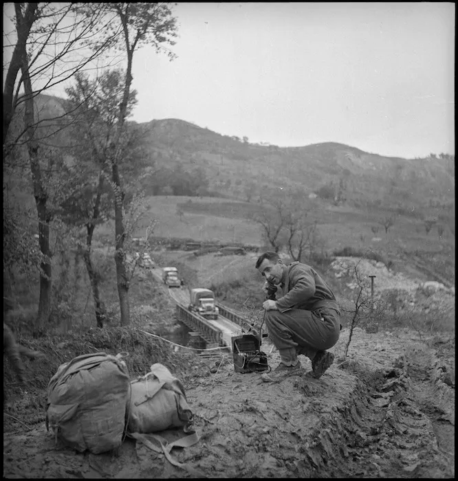 F M Maslim uses field telephone to regulate traffic over Bailey bridge, Italy, World War II - Photograph taken by George Kaye