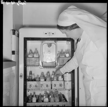Image: Nurse reaching inside a fridge for babies milk, Karitane Hospital, Christchurch