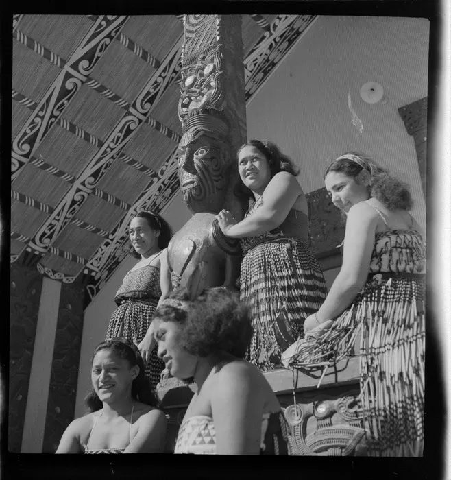 Wāhine, including guide Bubbles Mihinui, on the mahua/porch of the Wahiao whare nui, Whakarewarewa