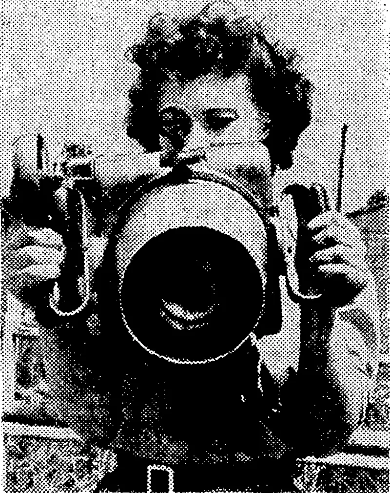 A member of the W.A.A.F., specially trained as an instrument repairer, checking the sights of an air camera. (Evening Post, 21 August 1941)
