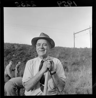 Image: A group planting trees on a railway embankment, featuring an unidentified man, Wellington region