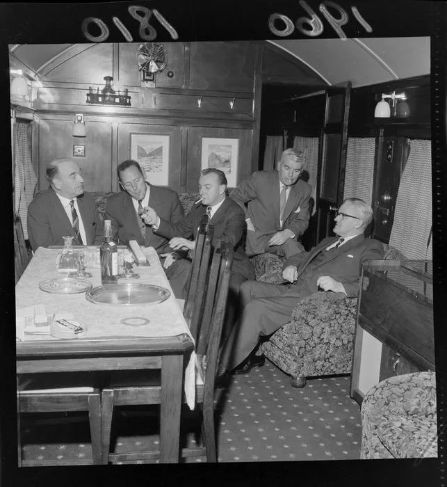 Minister of Railways Michael Moohan and a group of unidentified men, smoking inside a train carriage, on their way to Dannevirke