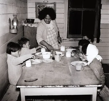 Image: The children seat themselves around the table. From the series: Washday at the pa