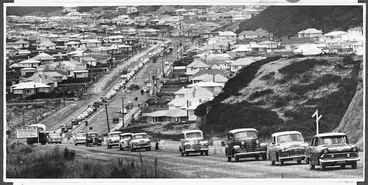 Image: Queue of cars driving on newly sealed road, Wainuiomata