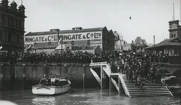 A crowd at the Auckland waterfront watching mail being loaded into the New Zealand Flying School seaplane Image: A crowd at the Auckland waterfront watching mail being loaded into the New Zealand Flying School seaplane