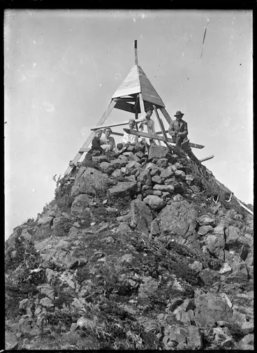 Image: A high point in the Rimutaka Range with a group of people around a trig station.