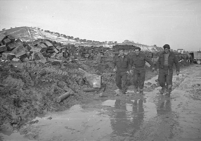Three members of the New Zealand forces tramping through mud and snow at the front in Italy during World War II
