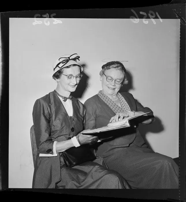 Jean Allardyce and E M Matheson who are both dressed up in two-piece outfits that include a hat, a fascinator, gloves and glasses