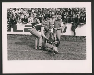 Rugby supporters hand a demonstrator off the Field, Hamilton. Image: Rugby supporters hand a demonstrator off the Field, Hamilton.