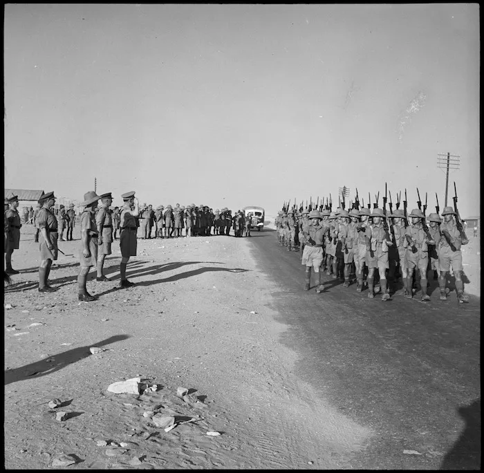 King of Greece takes the salute as the Auckland Battalion marches past, Helwan