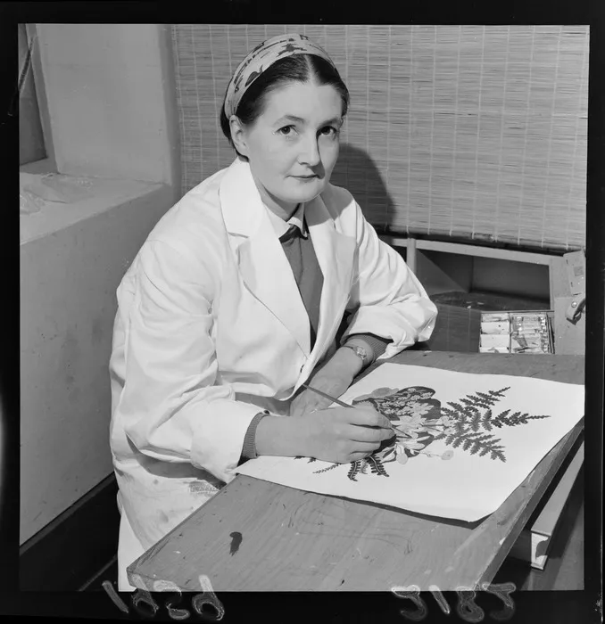 Nancy Mary Adams, artist at the Dominion Museum, working on a painting featuring flowers and ferns