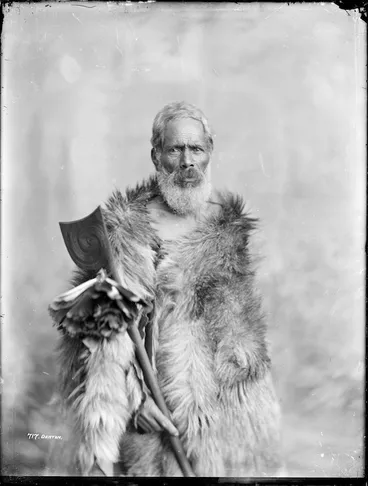 Image: Unidentified Maori man wearing a cloak and holding a tewhatewha - Photograph taken by Frank Denton