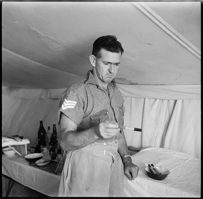 Member of field ambulance unit holding test tube, Egypt