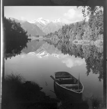 Image: An empty dinghy at Lake Matheson, South Westland, including Fox Glacier in the background
