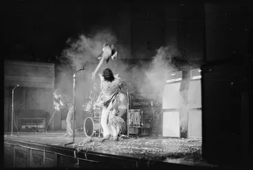 Image: Pete Townshend, throwing his guitar in the air while performing a concert with other members of The Who in Wellington