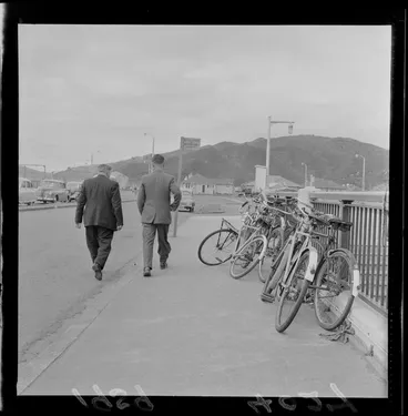 Image: Two unidentified men walking past bicycles crowding the footpath at Naenae railway station, Lower Hutt