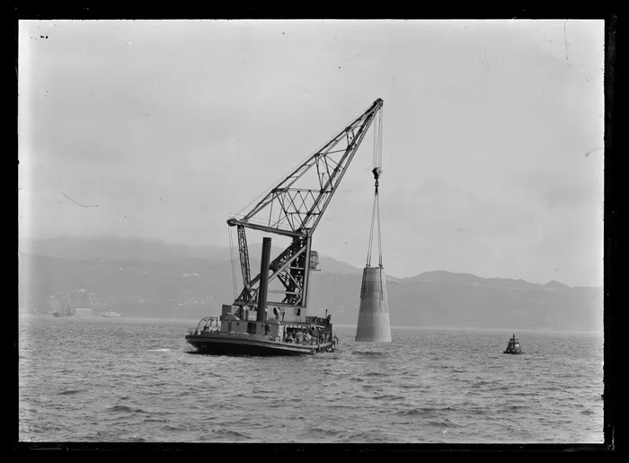 Floating crane Hikitia lowering concrete base for Point Jerningham lighthouse, Wellington harbour