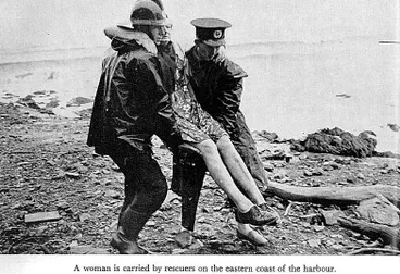 Image: A woman is carried by rescuers on the eastern coast of the harbour