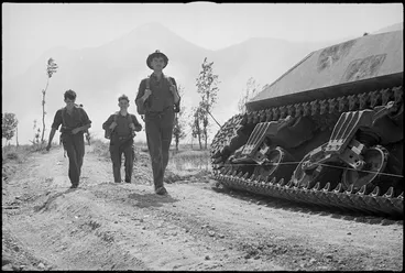 Image: Infantrymen leaving ruins of Cassino pass knocked out tank, Italy, World War II - Photograph taken by George Kaye