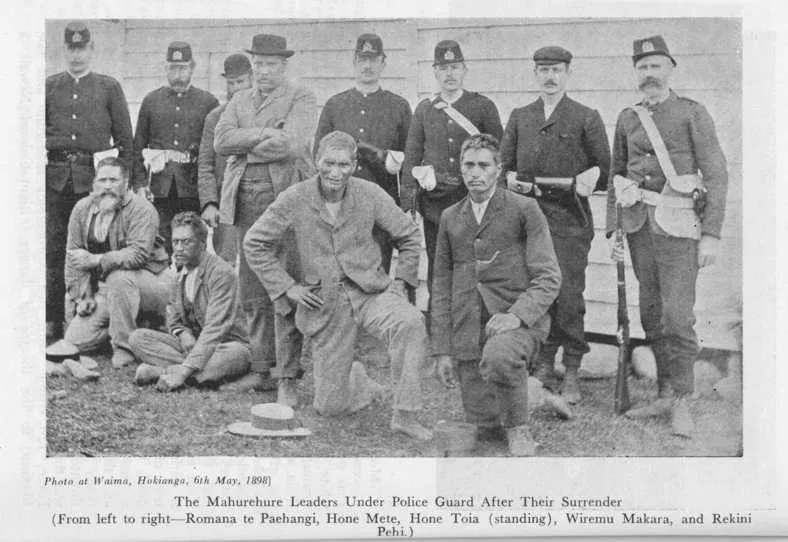 Photo at Waima, Hokianga, 6th May, 1898] — The Mahurehure Leaders Under Police Guard After Their Surrender (From left to right—Romana te Paehangi, Hone Mete, Hone Toia (standing), Wiremu Makara, and Rekini Pehi.)