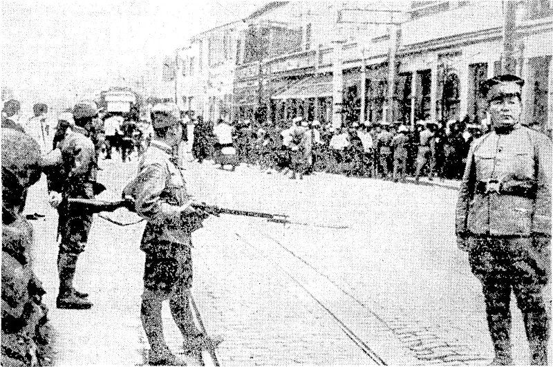 Armed Japanese soldiers on guard in the vicinity of the British Concession at Tientsin, ivhere the Japanese are reported to be intensifying the anti-British boycott. (Evening Post, 22 July 1939)