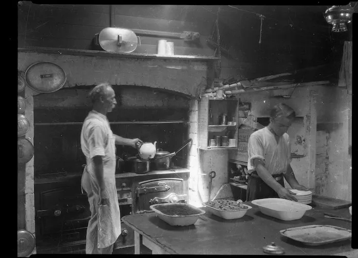 Two men preparing food in a kitchen