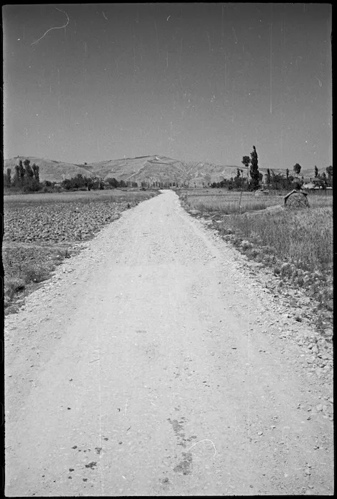 Deserted road leading to Tiki Bridge once scene of heavy fighting, Sangro River area, Italy, World War II - Photograph taken by George Kaye