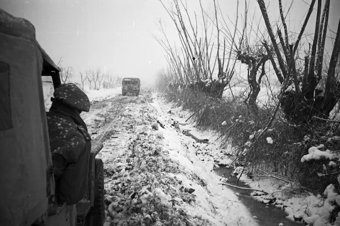 Two trucks on a snow covered road, Italy