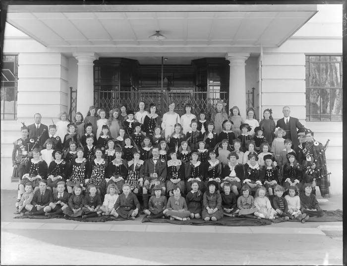 Group of unidentified children and adults, most in Scottish Highland costume outside the Caledonian Hall, Christchurch