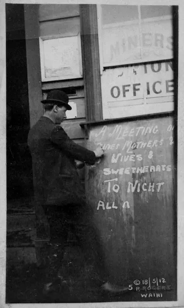 Image: Man writing a sign announcing a meeting during the Waihi miners' strike