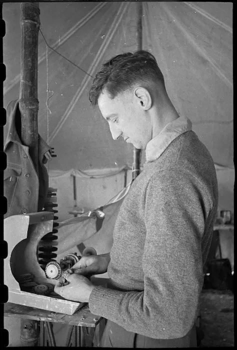 W A Clark polishes a denture at Headquarters of the 1 New Zealand Mobile Dental Unit, Volturno Valley, Italy - Photograph taken by George Bull