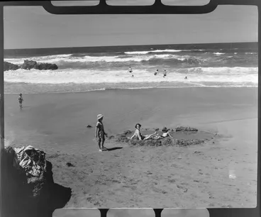 Image: Unidentified woman and child sitting in a pool at Hot Water Beach, Thames-Coromandel district