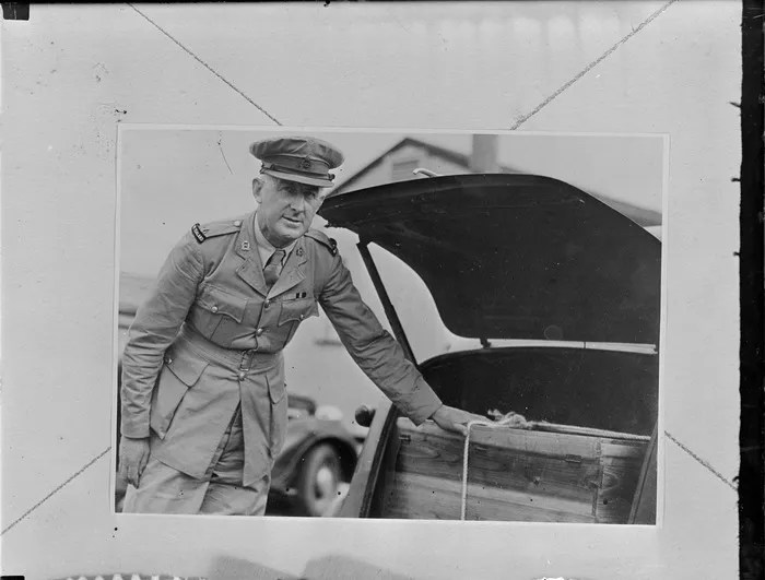 Major Pollock with NZ Services [J-Force] votes from Japan, with one hand on a box in the boot of a motor vehicle