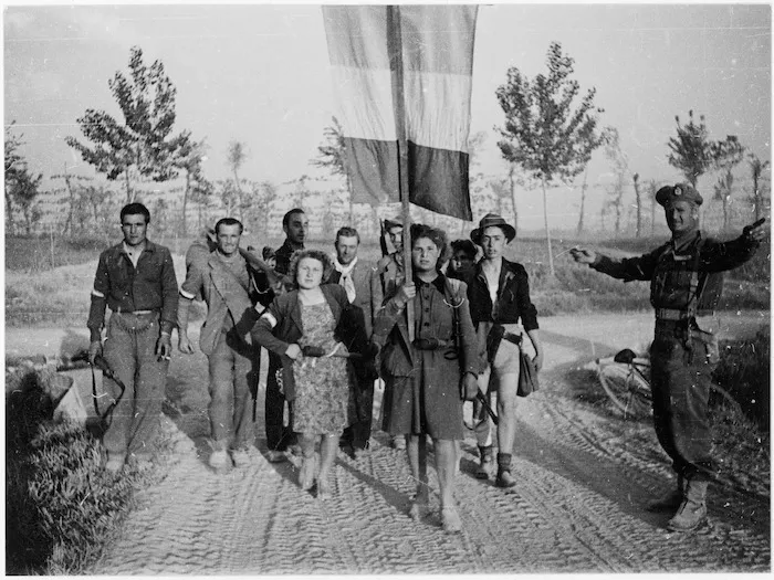 A band of partisans passing a New Zealand provost on duty near the Reno River, Italy