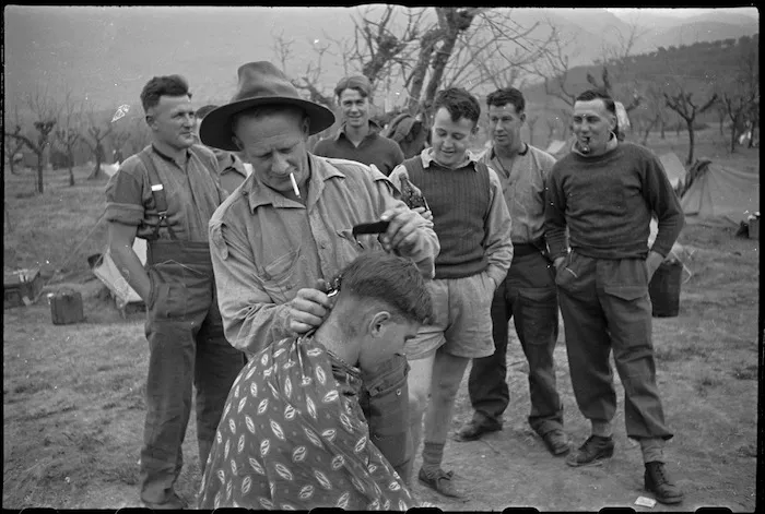 NZ Infantry soldier has haircut behind the lines on the Cassino Front, Italy, World War II - Photograph taken by George Kaye
