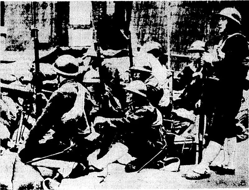 Japanese landing forces in the streets of Shanghai prepare for an attack from Chinese regulars. A group of marines is seen standing behind a barricade of sandbags in the streets of Shanghai. (Evening Post, 23 August 1937)
