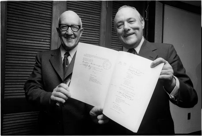 Sir Arnold Nordmeyer, chairman of the Government owned Offshore Mining Company Ltd, and Mr Muldoon, Prime Minister, holding the $(US)200,000,000 credit agreement they had just signed with representatives of an international syndicate of banks