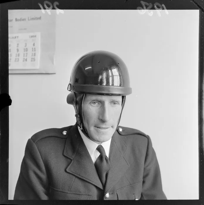 An unidentified official [policeman?] models a safety helmet at the time they became compulsory for motorcyclists