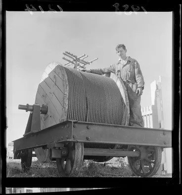 Image: Unidentified man with a large roll of cable to be fitted on the cable car, Wellington