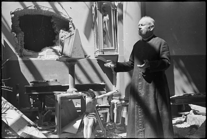 Village priest standing in the ruins of his church in San Michele, Italy, during World War II - Photograph taken by George Kaye