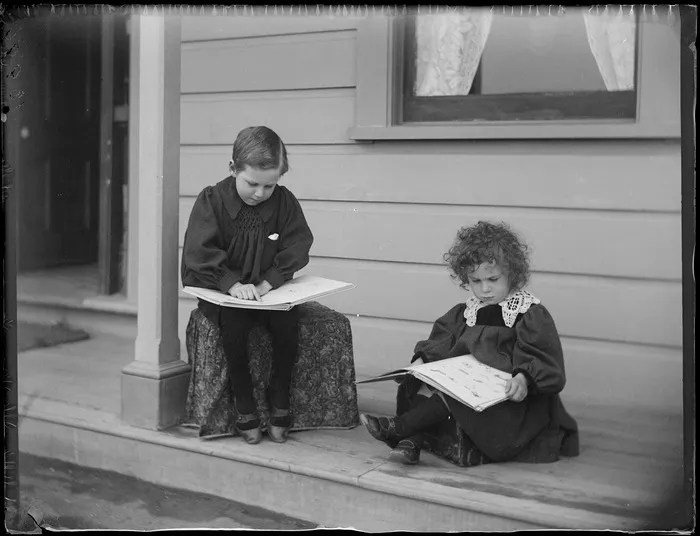 Portrait of brothers (L to R) Edgar and Owen Williams reading books on the veranda of their home at Royal Terrace in the suburb of Kew, Dunedin City