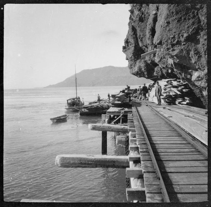 Timber being loaded off the wharf at Whatipu, Piha tramway in foreground.
