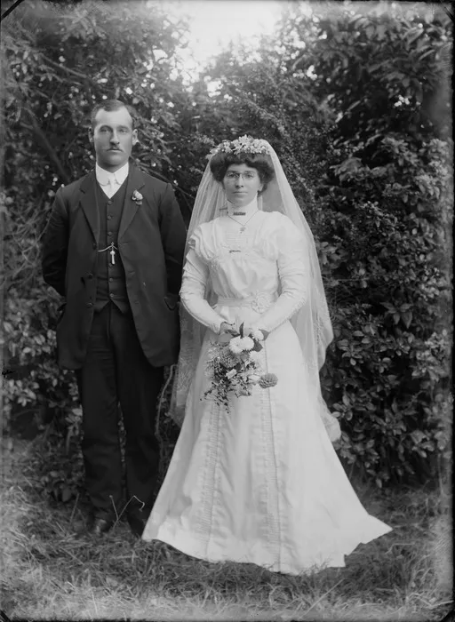 Unidentified bride and groom, outdoors, shows bride wearing spectacles, probably Christchurch district