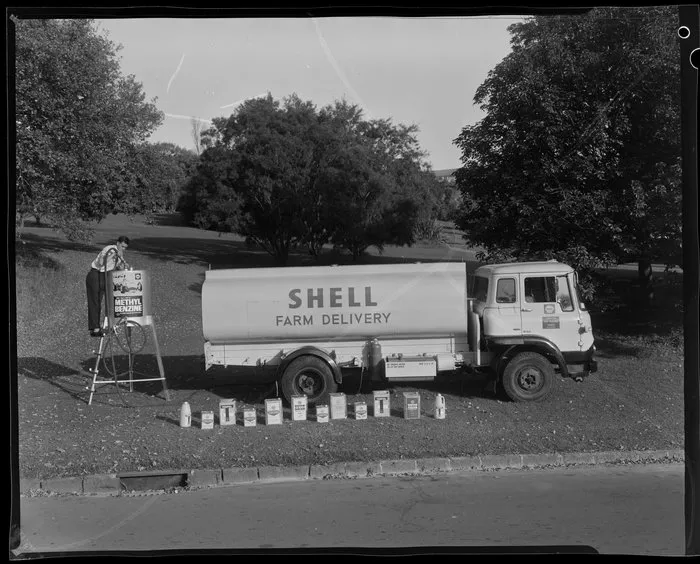 Shell farm delivery tanker truck with worker filling methyl benzine tank
