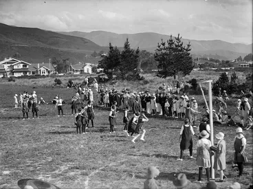 Image: Young women playing netball and a group of spectators at the sideline