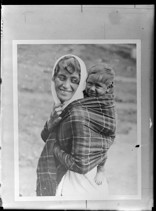 Annie Ngauru Hoko (nee Downs) woman carrying a young child on her back wrapped in a blanket