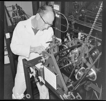 Image: Unidentified man, adjusting parts to the Totalisator machine, Trentham Racecourse, Lower Hutt, Wellington