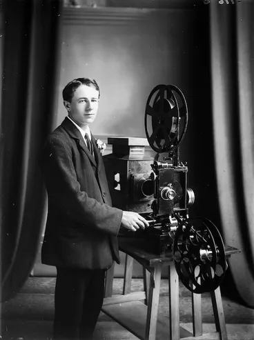 Image: Motion picture projectionist alongside a projector